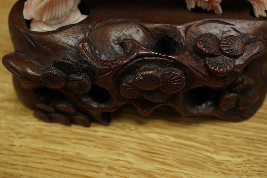 A Chinese coral group of a lady and a phoenix on carved hardwood base, 11cm high. Condition - good